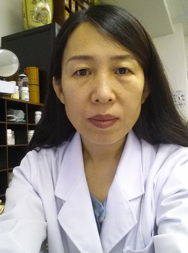 Portrait of Dr. Yang in a clinical office.
